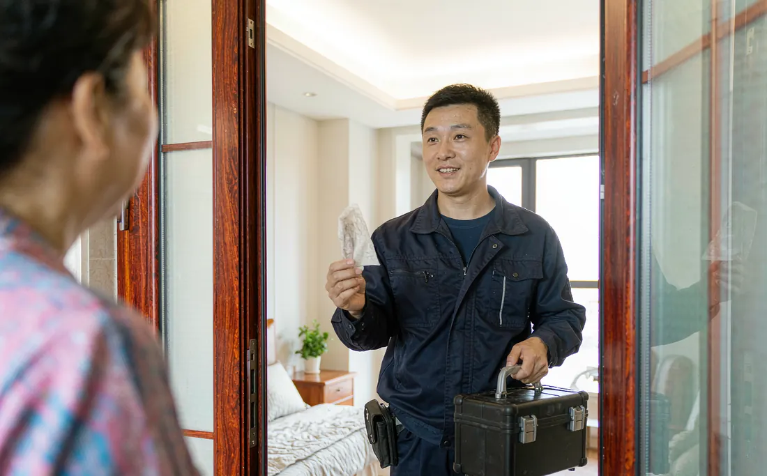 Technician arriving at an apartment door with a tool case